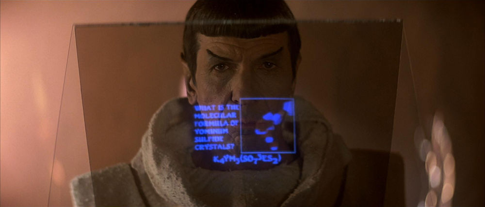 Spock standing in front of a transparent screen, looking at a possibly fictitious chemical compound.