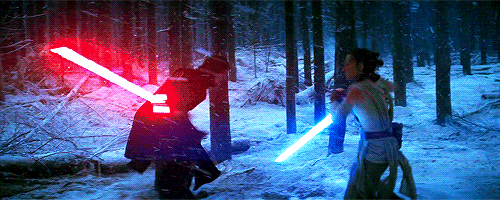A GIF of Rey and Kylo Ren fighting with lightsabers in a snowy forest from The Force Awakens.