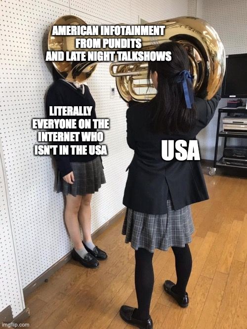 I made this meme. The person holding the tuba represents the USA, the tuba represents "American Infotainment from Pundits and Late Night Talkshows" and the second person whose stuck between the tuba and the wall is "Literally Everyone On The Internet Who Isn't Based In The USA."