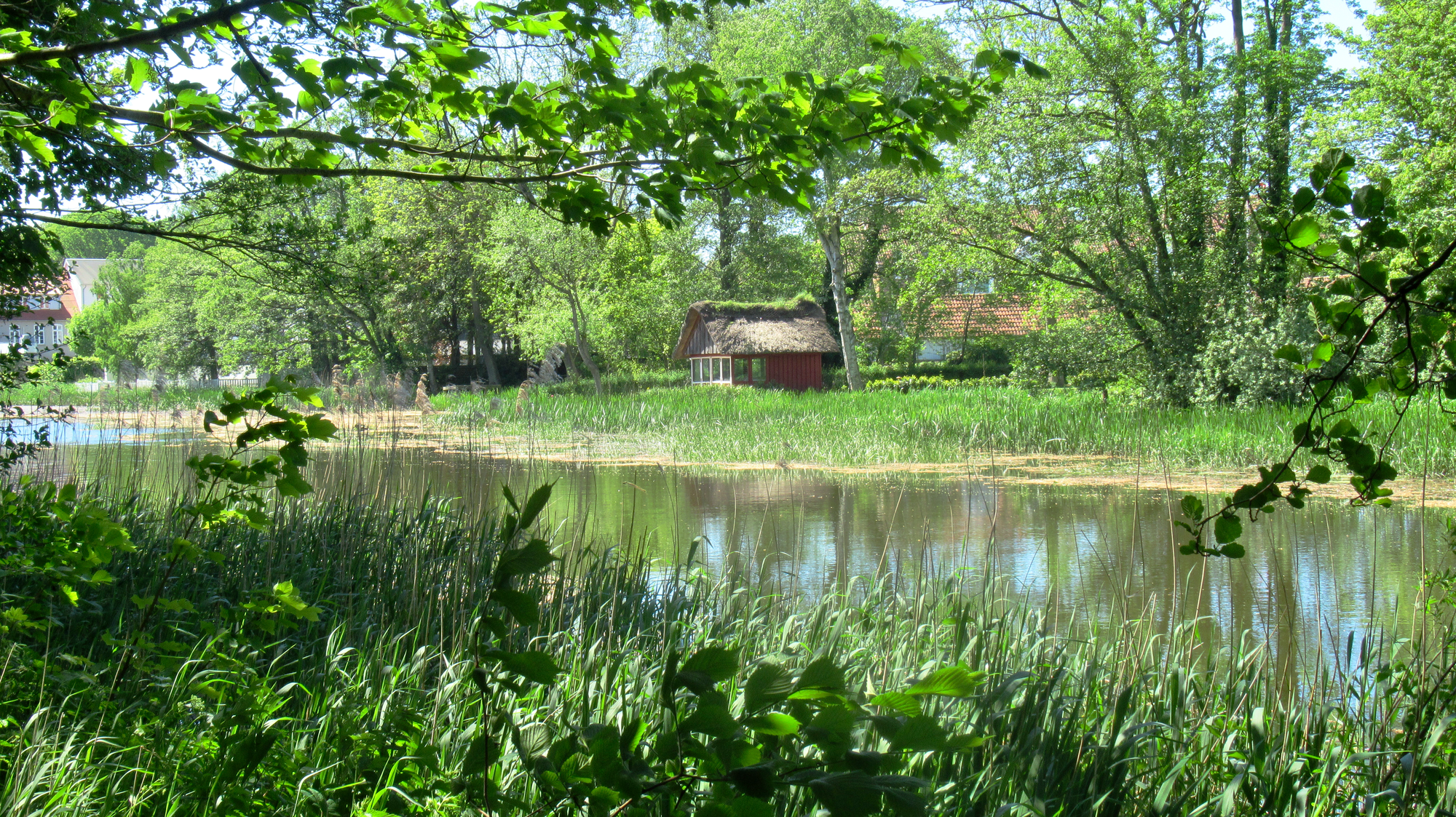 On the Vidå stream, a little boathouse has a characteristic thatched hay roof.