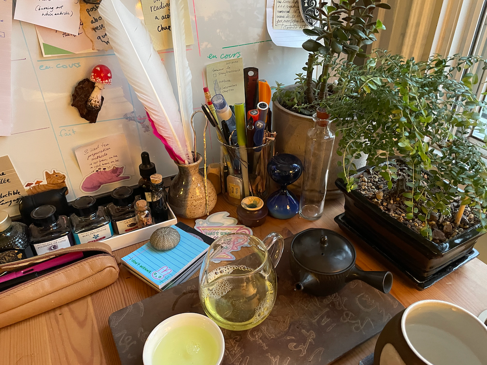 A photo of the corner of my desk, with a bunch of things scattered about in a pleasing way.