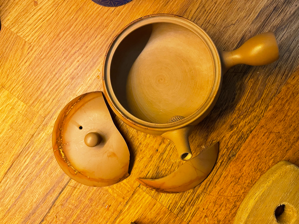 A photo of a fine ceramic tea pot with a broken top.
