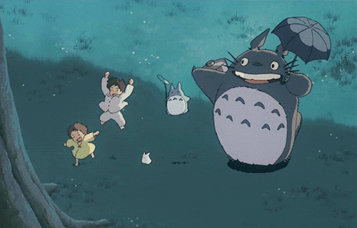 Les personnages de Mon voisin Totoro en train de danser avec joie devant un arbre sacré.