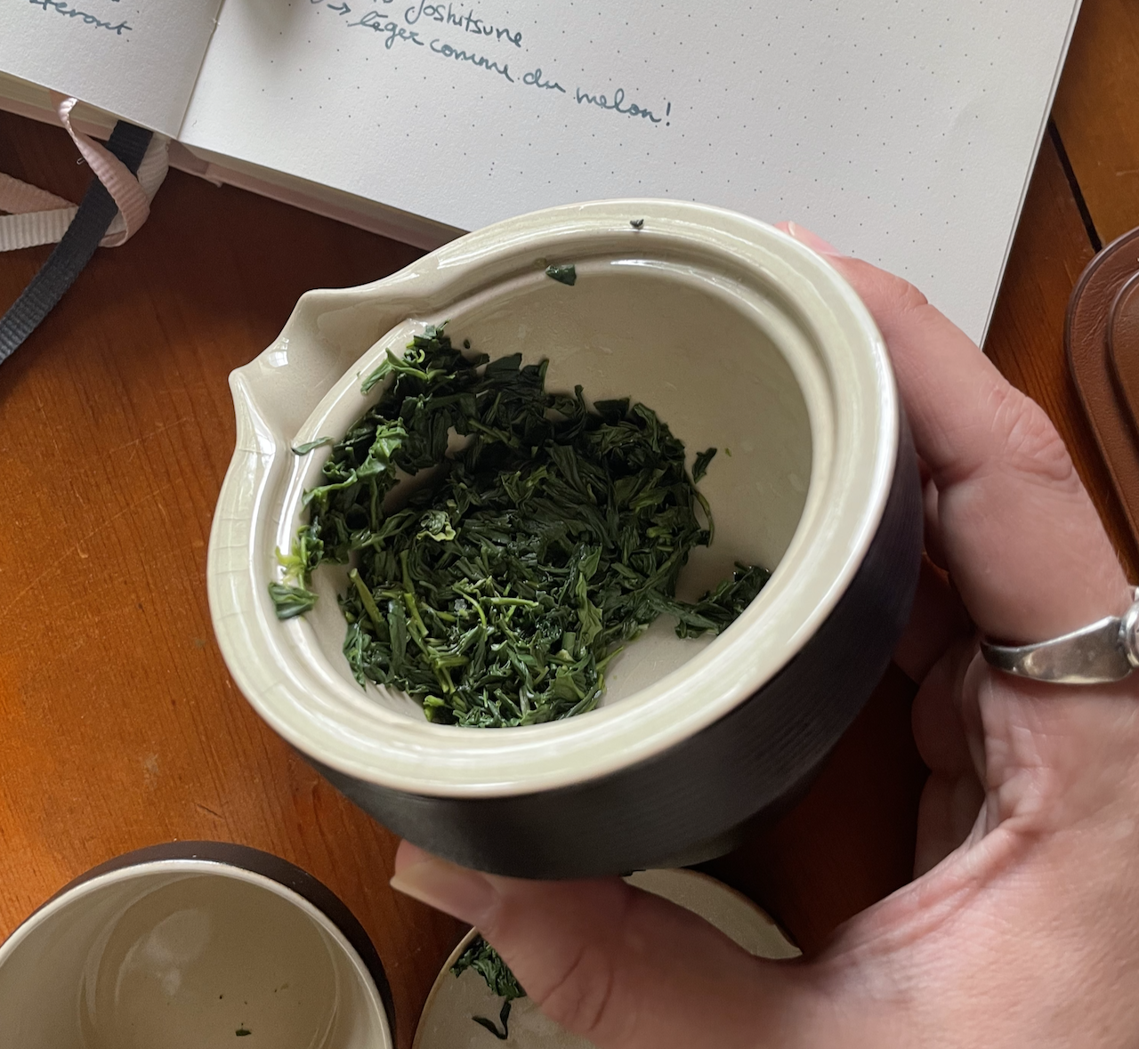 The inside of a travail gaiwan which has the bright green leaves of gyokuro after the first or second infusion.